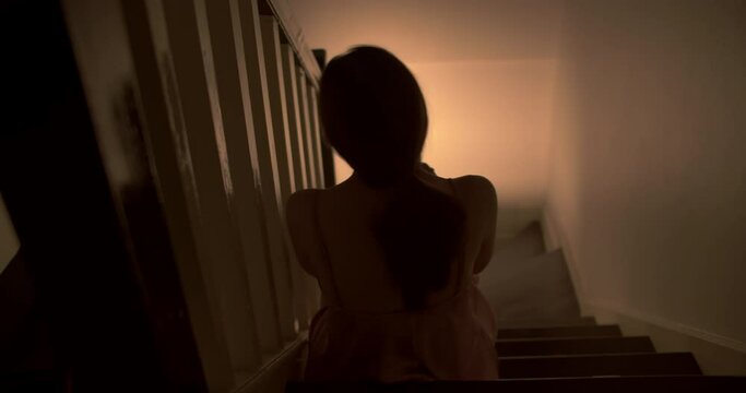 A lonely woman is sitting on the stairs at night . This concept use for symptoms of stress, major depressive disorder (MDD), psychotic symptoms. 