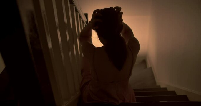 A lonely woman is sitting on the stairs at night . This concept use for symptoms of stress, major depressive disorder (MDD), psychotic symptoms. 