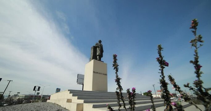Low view of a monument statue of the mexican ex-president Francisco Zarco while going through a plant in a roundabount in the city of Mexicali