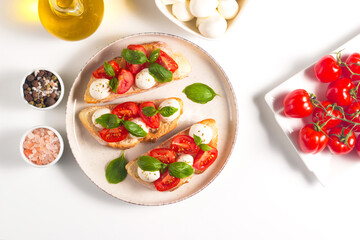 Tomato, basil and mozzarella cheese fresh made caprese bruschetta. Italian tapas, antipasti with vegetables, herbs and oil on grilled ciabatta and baguette bread. Open sandwich.