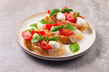 Tomato, basil and mozzarella cheese fresh made caprese bruschetta. Italian tapas, antipasti with vegetables, herbs and oil on grilled ciabatta and baguette bread. Open sandwich.