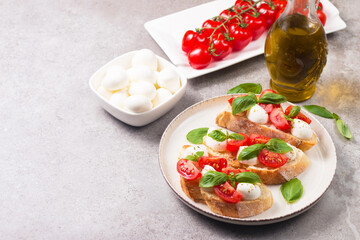 Tomato, basil and mozzarella cheese fresh made caprese bruschetta. Italian tapas, antipasti with vegetables, herbs and oil on grilled ciabatta and baguette bread. Open sandwich.