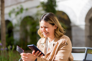 Fototapeta premium frustrated young woman buying in line with credit card