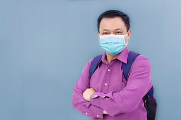 Fototapeta na wymiar Professional Asian business man wears purple shirt and medical face mask to protect his respiratory system from COVID19 or pathogen and pollution in healthcare lifestyle on grey color background.