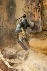 an old faucet on a stone wall