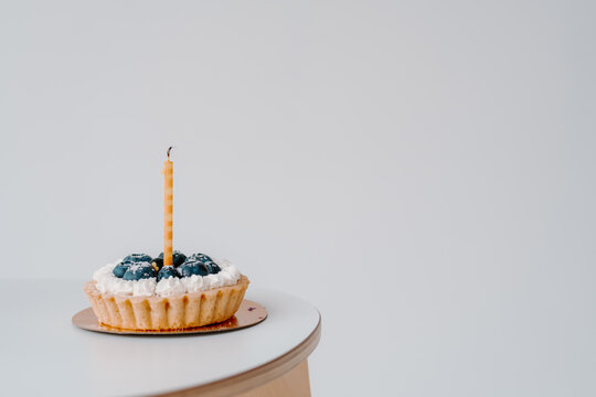 Birthday cake with blueberries and one extinguished candle