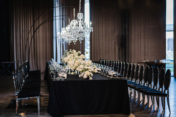 Trendy decor large chandelier for a birthday party. Luxury wedding reception. Table setting, setup....