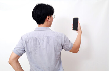 Back view photo of asian man holding a cell phone. Isolated on white