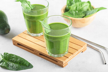 Healthy green smoothie with spinach, avocado, banana, and vegan milk in two glasses and fresh ingredients
