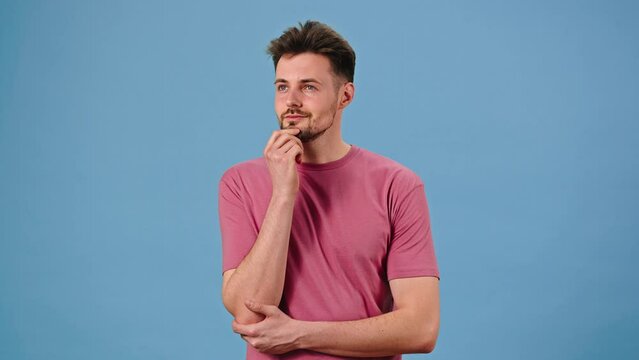 Young bearded man ponders question rubbing chin excitedly