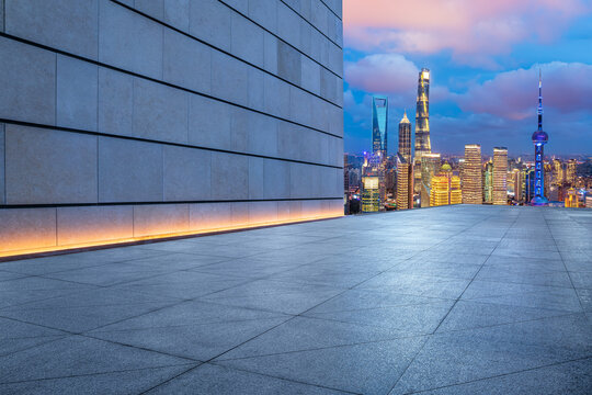 Empty square floor and city skyline with modern building at night in Shanghai, China.