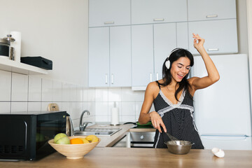 attractive smiling woman in pajamas having breakfast in kitchen