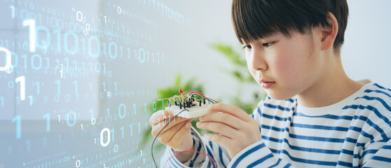 電子工作をする少年とデジタルイメージ