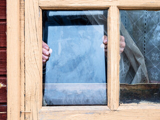 installation of window glass in wooden frame in rural house close up