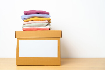 Donation, Charity, Volunteer, Giving, Delivery and Home Moving Concept. Clothes with cardboard box at home or offices for support and help poor, refugee and homeless people. Copy space for text