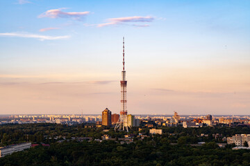 Incredible ruff top view on TV tower in Kyiv during sunset golden hour time with nice gradient sky color in not cloudy evening.