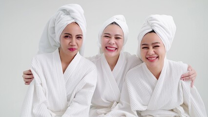 Portrait group of beautiful young asian women in bathrobes and towels on heads smiling looking at camera feeling happy