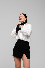 Portrait of an attractive young Stewardess. Charming, smiling air hostess in sensual uniform. Isolated on white background. Studio shoot.