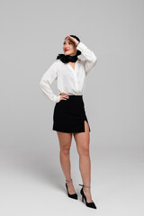 Attractive young Stewardess. Charming, smiling air hostess in sensual uniform makes salute gesture....