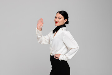 Portrait of an attractive young Stewardess. Charming, smiling air hostess in sensual uniform waving...