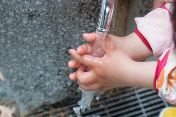 公園の蛇口で手を洗う可愛い子どもの手