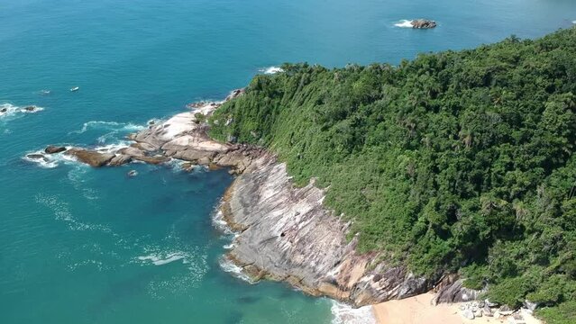 Vista &aacute;rea de praia deserta com rochas e floresta