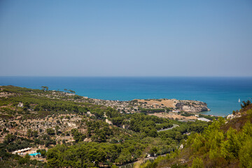 The view from the hill of the sea coast, buildings of Peschici, Puglia, Italy. Vacation on the Adriatic sea