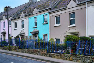 Row of colorful stucco townhouses with slate shingle roof
