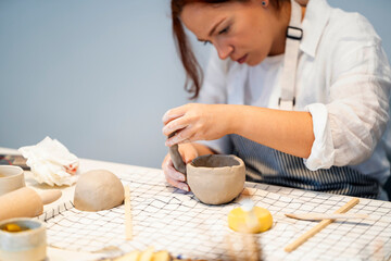 Woman making handmade clay bowl
