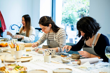 Cheerful women having pottery lesson in studio