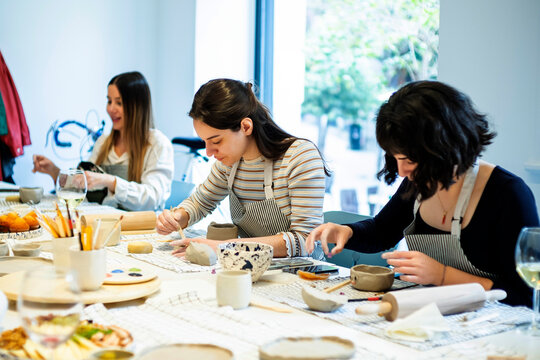 Cheerful women having pottery lesson in studio - Powered by Adobe