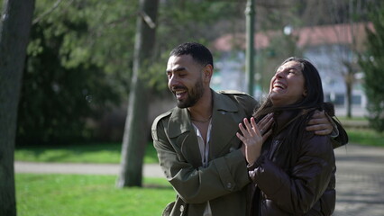 Happy Arab Couple Enjoying Sunny Stroll at Park with Genuine Laughter and Smiles