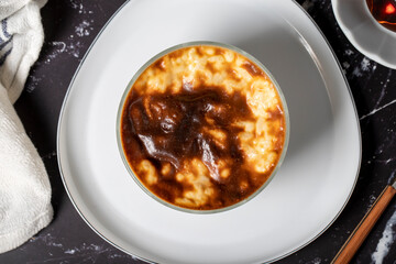 Rice pudding on a dark background. Rice pudding dessert made with milk. Turkish cuisine delicacies. Local name sütlaç. Top view