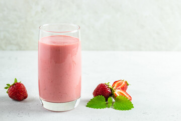 Strawberry smoothie, greek yogurt milkshake in glass with mint leaves.