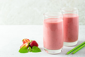 Dairy free vegan strawberry coconut milk smoothie, yogurt milkshake in glass with mint leaves.