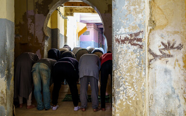 Fototapeta na wymiar men praying outside a mosque, Fez, morocco, africa
