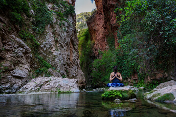 woman practicing yoga by the river, God's Bridge, Akchour, Talassemtane Nature Park, Rif region,...