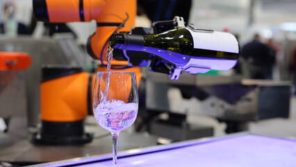 Futuristic automated robotic arm pours liquid into a glass.