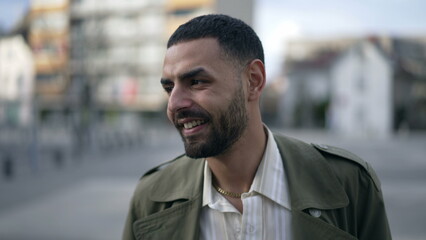 A content Arab man strolls down city. Tracking shot of a thoughtful Middle Eastern male wearing a jacket portrait face closeup in motion