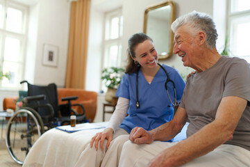 Young nurse checking elderly senior in his home.