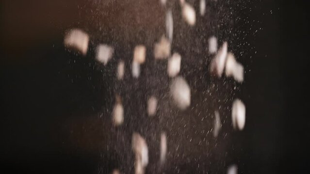 Crushed stone.Construction gravel for cement mix close-up pour down on a black background. Slow motion. Cinematic. Object shooting