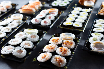 A view of several trays of sushi rolls.