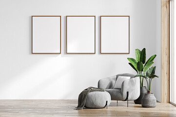 Fototapeta na wymiar Mock-up frame in cozy light home interior background with gray armchair and three frames. 3d render
