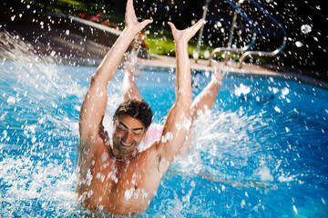 Healthy lifestyle: couple having fun at the swimming pool