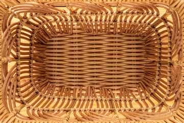 One basket woven from vines on a wooden table, close-up, top view.