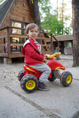 Cute kid on a quad bike. Quad bike in a summer park.