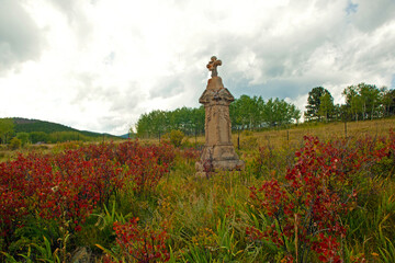 Stunning headstone with red flaming bushes clustered around it 