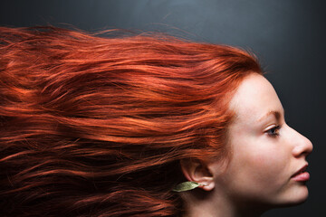 Pretty redhead young woman profile with hair streaming out behind her. - obrazy, fototapety, plakaty