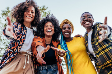 Cheerful diverse friends showing welcome gesture with hands