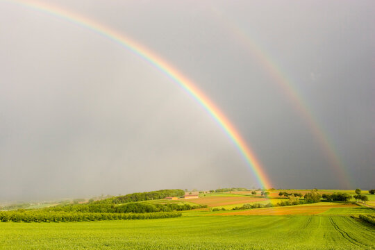 Half rainbow over a rural landscape with intensive colors